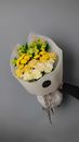 Unrecognized Hand Holding Bouquet of Yellow Flowers