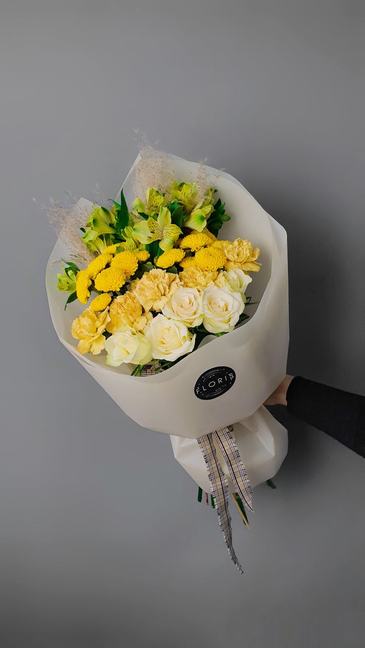 Unrecognized Hand Holding Bouquet Of Yellow Flowers