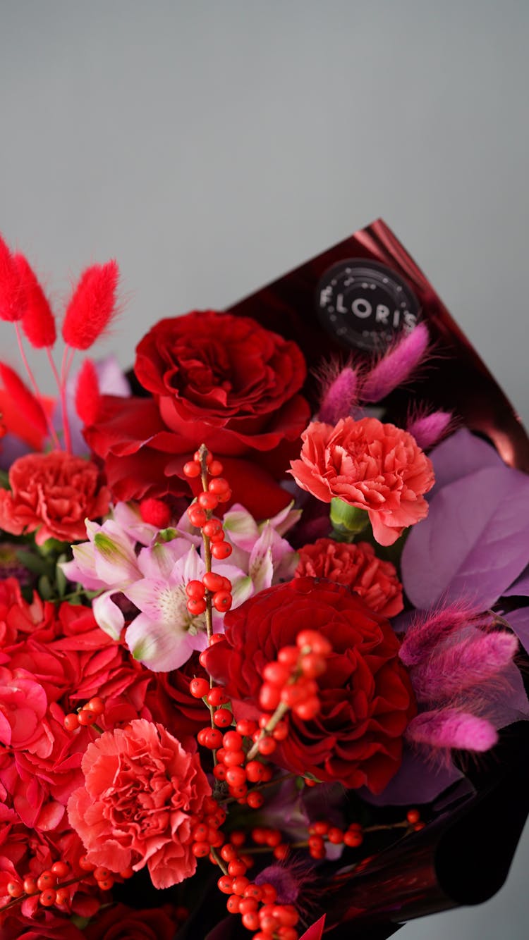 Bunch Of Red And Pink Flowers Wrapped In Black Paper With Logo Of Florist