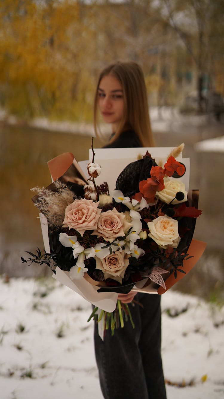 Young Woman Presenting Pastel Bouquet Of Cut Flowers