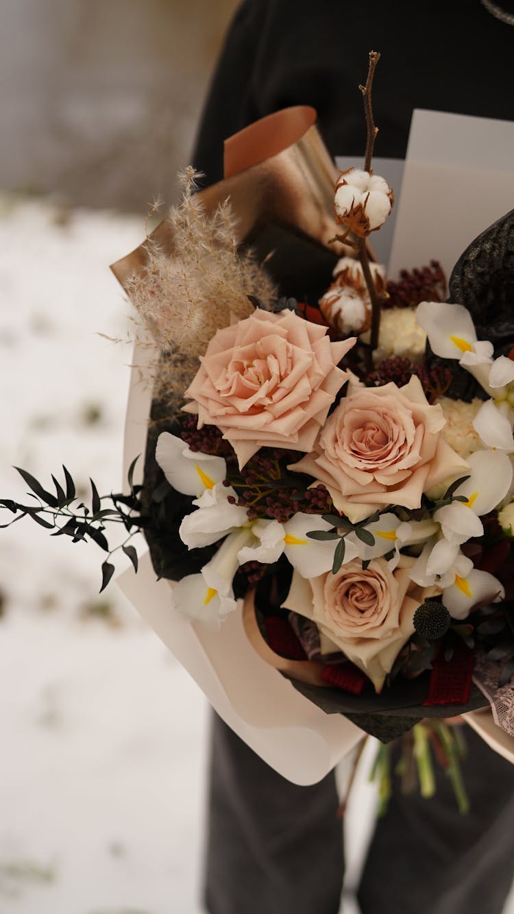 Unrecognized Person Presenting Bouquet Of White Irises And Pale Pink Roses