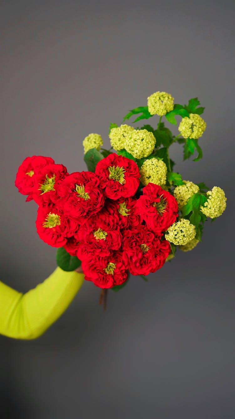 Unrecognized Hand Holding Bunch Of Red And Yellow Flowers