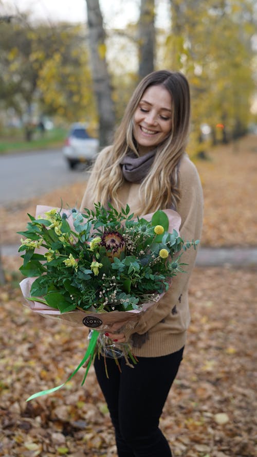 Pretty Woman Holding a Bouquet of Flowers