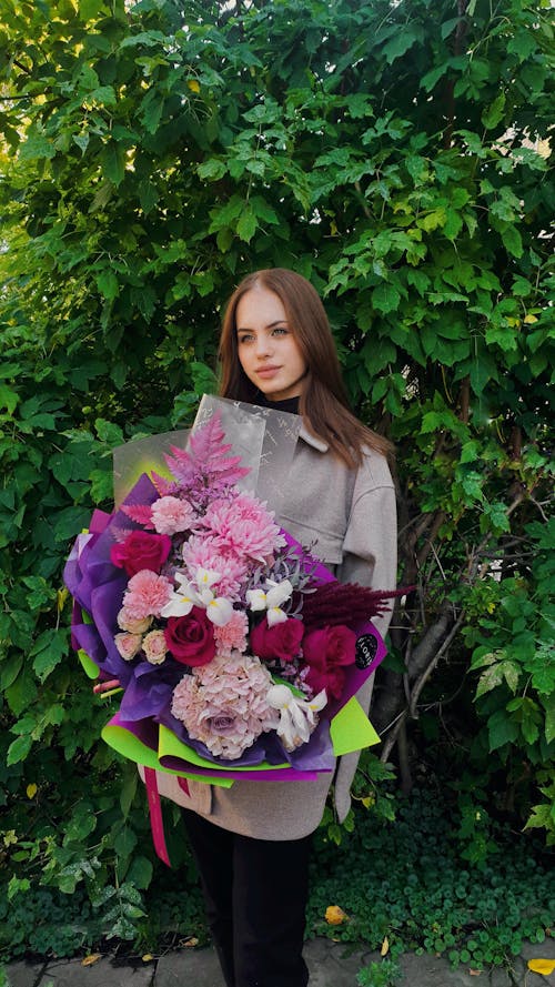 Pretty Woman Holding a Big Bouquet of Flowers