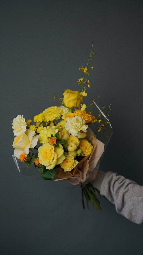 Free Hand Holding Bouquet of Yellow Flowers Stock Photo