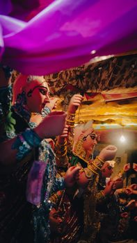 Colorful sculptures of deities in an indoor festival setting with decorative lights.