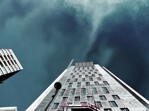 Фотосъемка белого многоэтажного дома в штормовую погоду с видом на черви