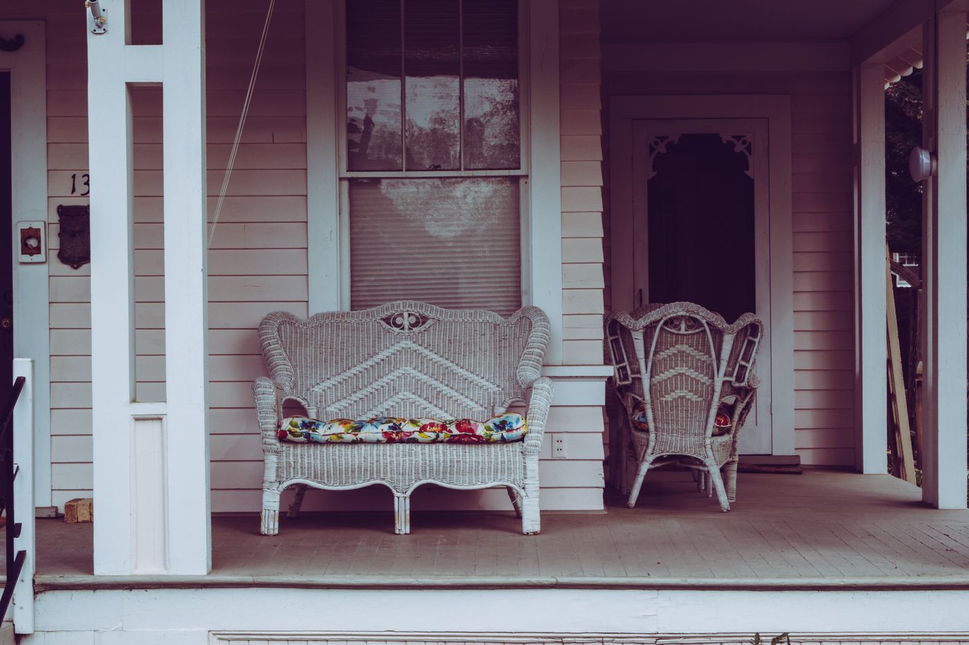 Vintage front porch with white wicker furniture