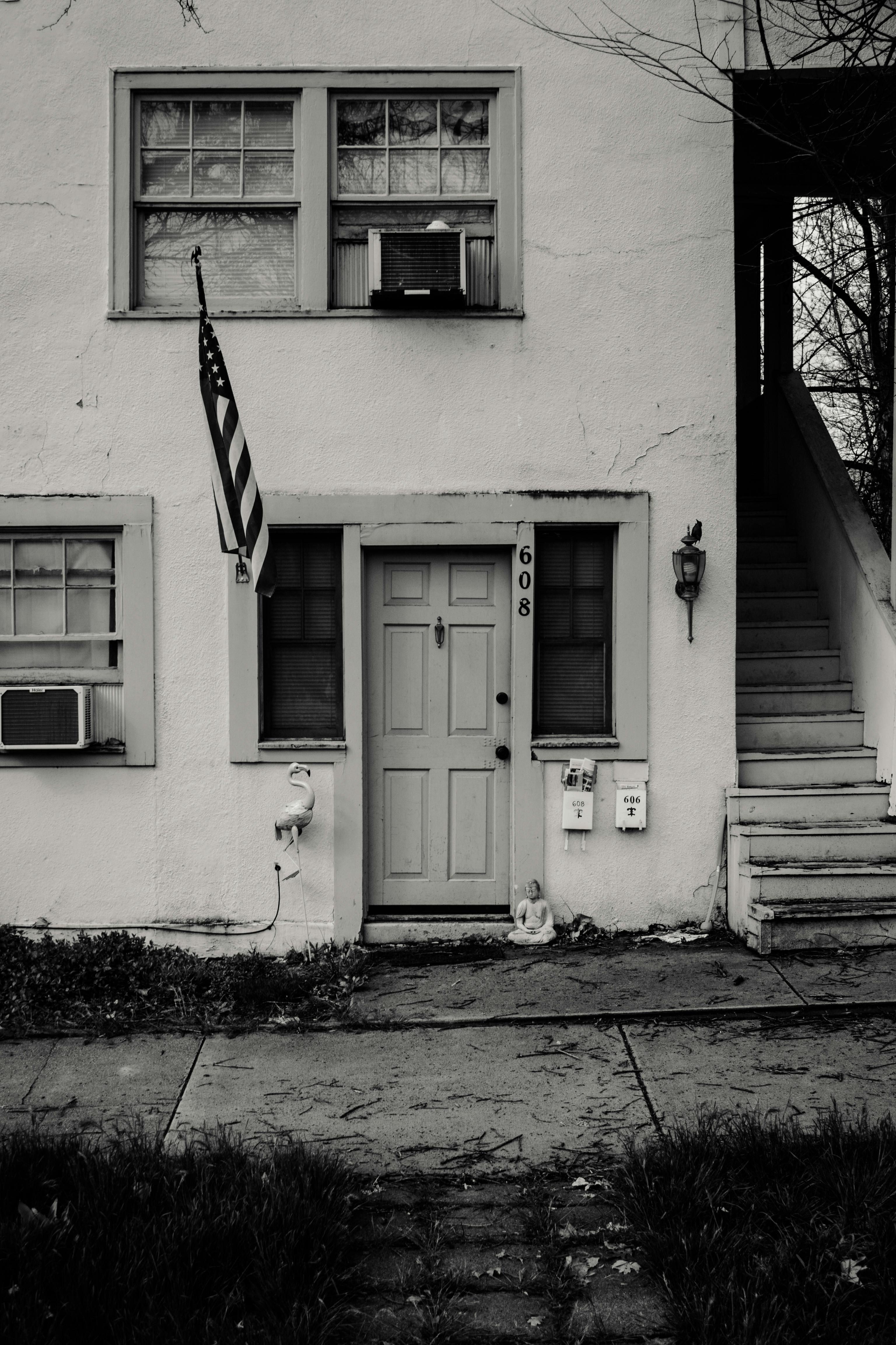 grayscale photo of concrete house with usa flag