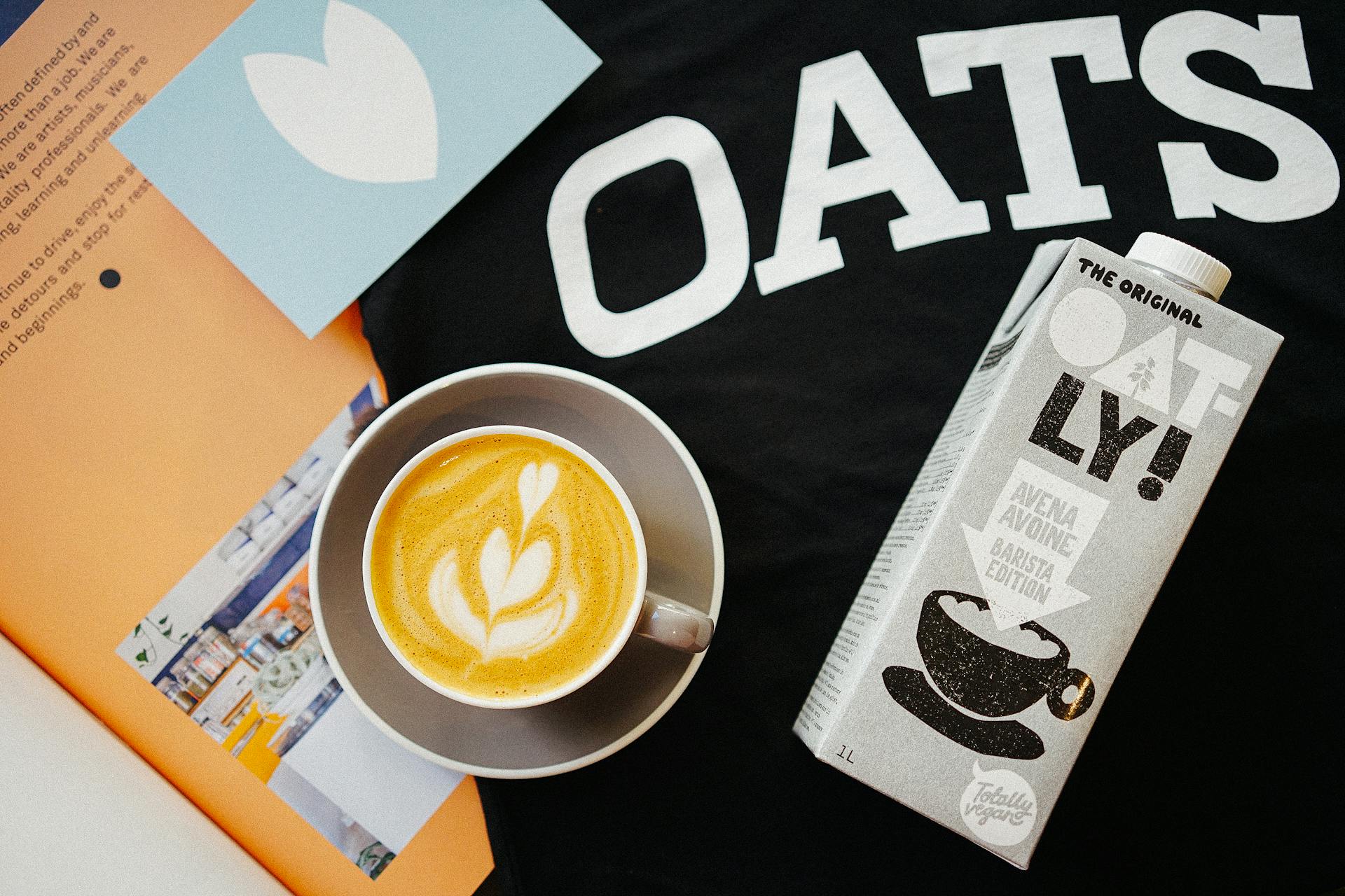 Stylish flatlay featuring a cappuccino with oat milk and creative packaging.