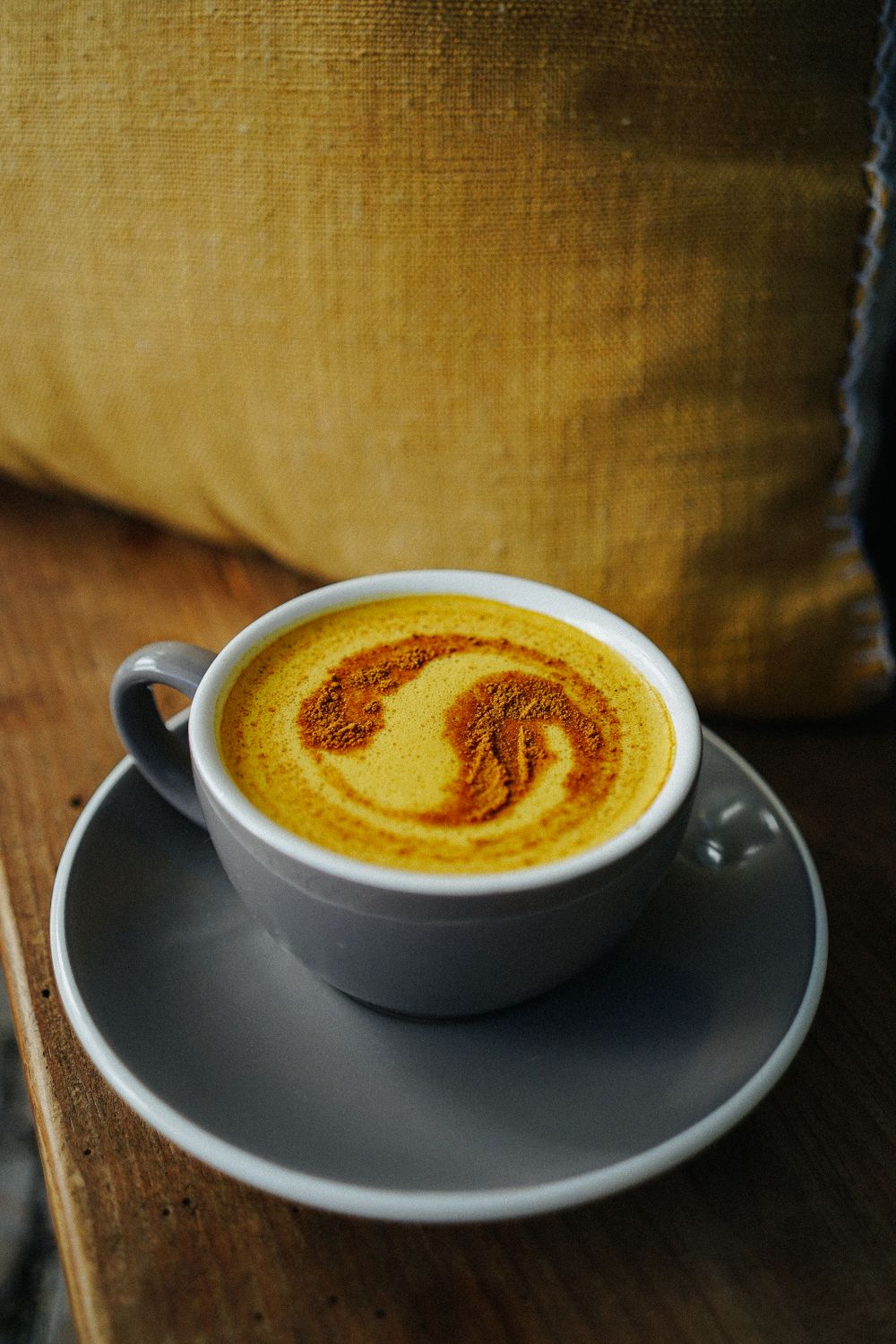 Golden latte doré au curcuma surmonté d'une mousse de lait et d'une pincée de cannelle