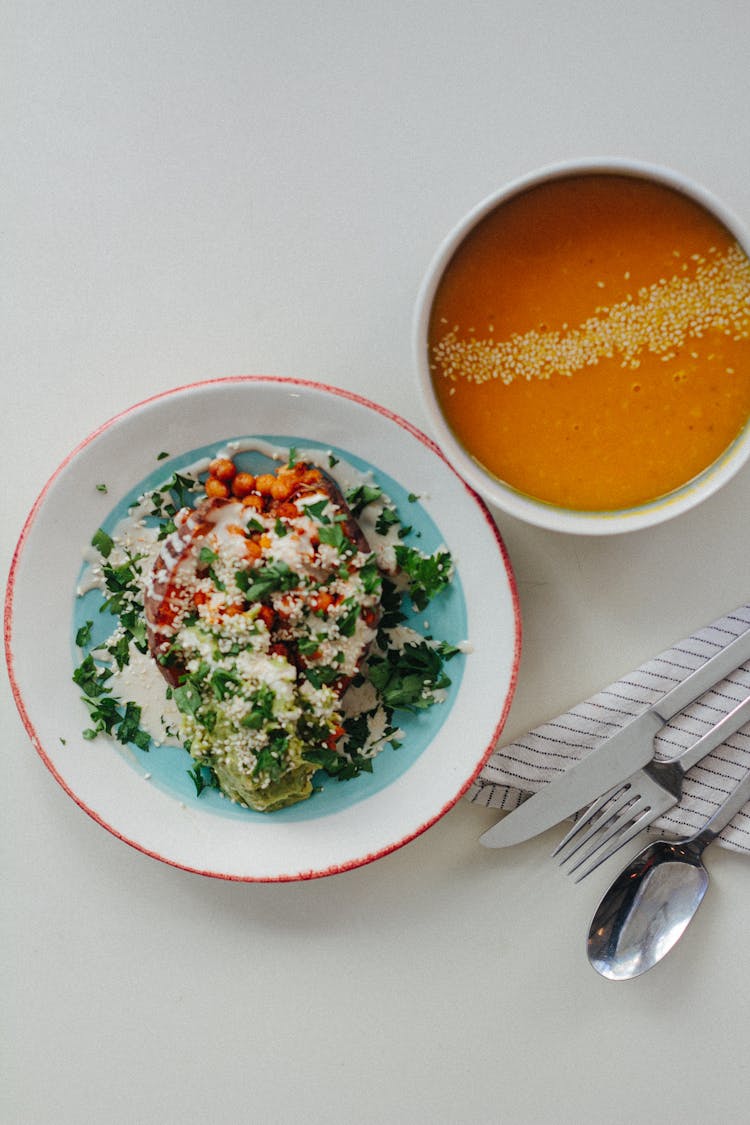 Salad And Pumpkin Soup On Table