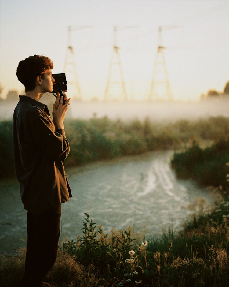 Young Man Filming With A Retro Camcorder 