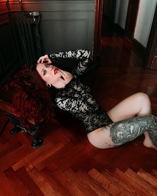 A Woman Wearing Black Lace Bodysuit While Posing Seductively