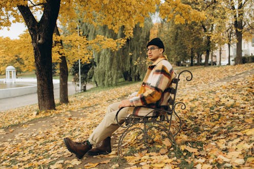 A Man Sitting on the Bench of the Park While Looking Afar