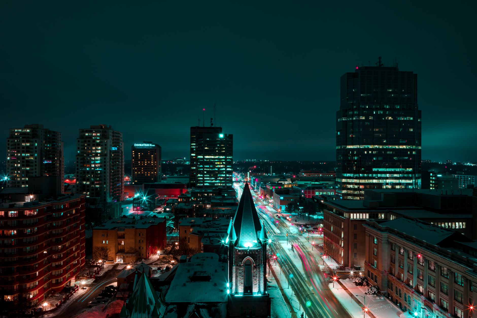 Stunning aerial night view of London, Ontario's downtown with vibrant light trails and illuminated buildings.