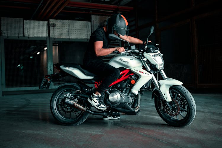 Man In Black Shirt Riding On A White And Black Sports Bike