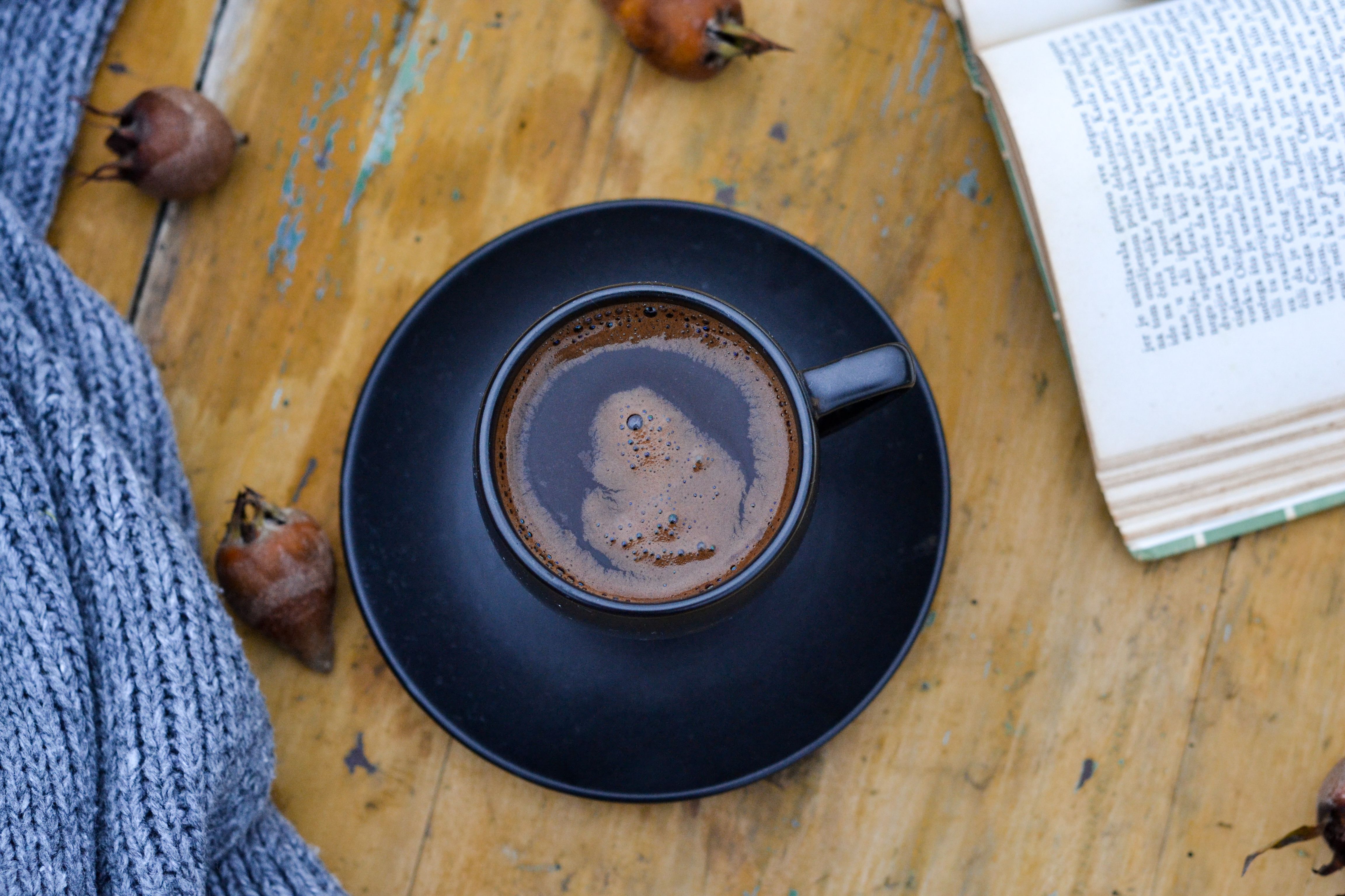 A cozy setup with a cup of black coffee on a wooden table. Perfect for reading moments.