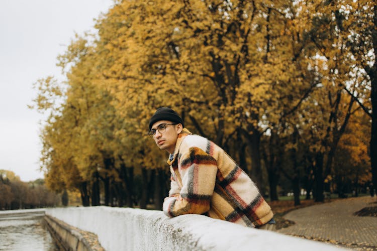 Person In Plaid Jacket Leaning On Concrete Railing