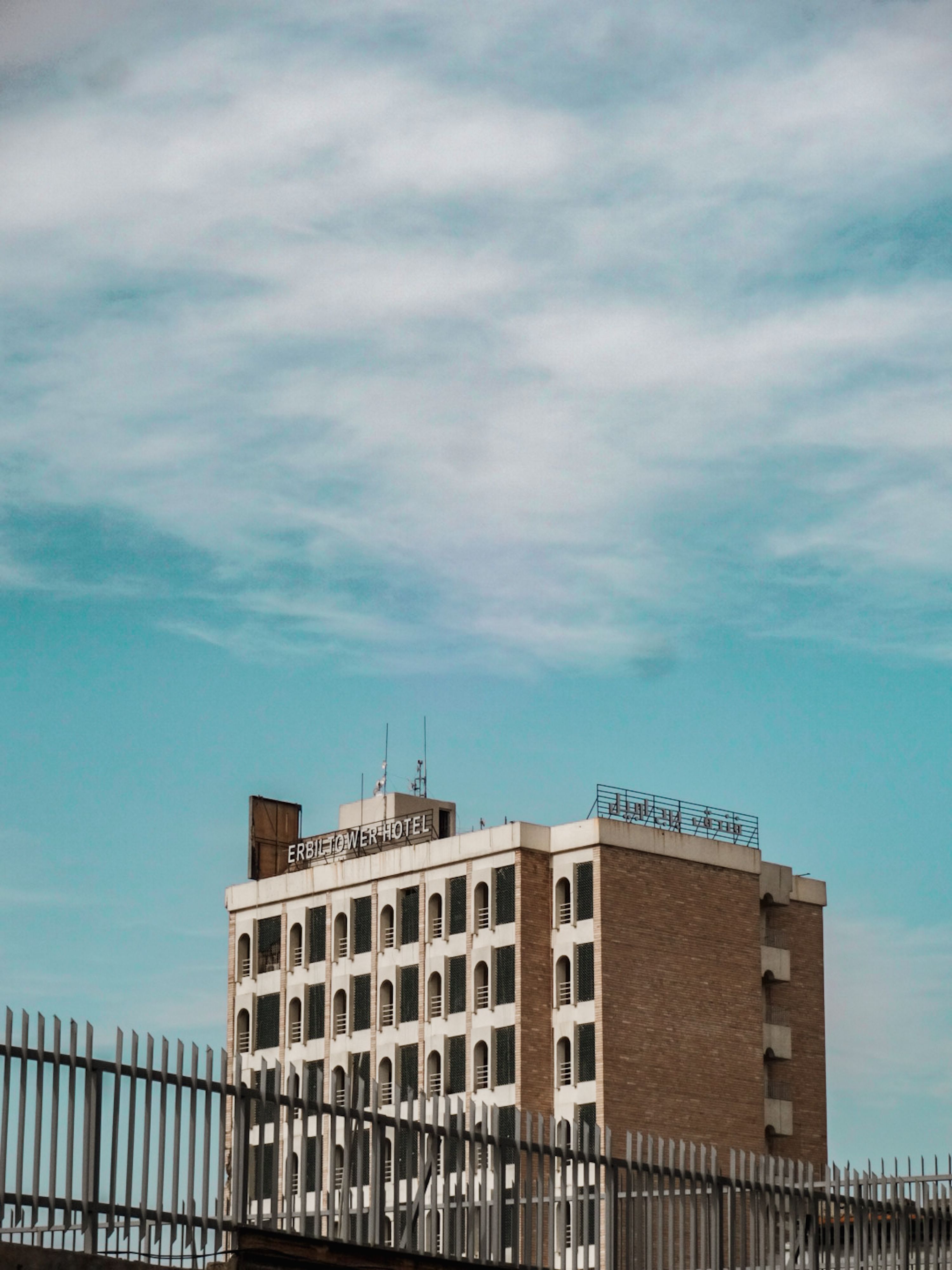 A classic hotel building exterior with blue sky and clouds, showcasing urban architecture.