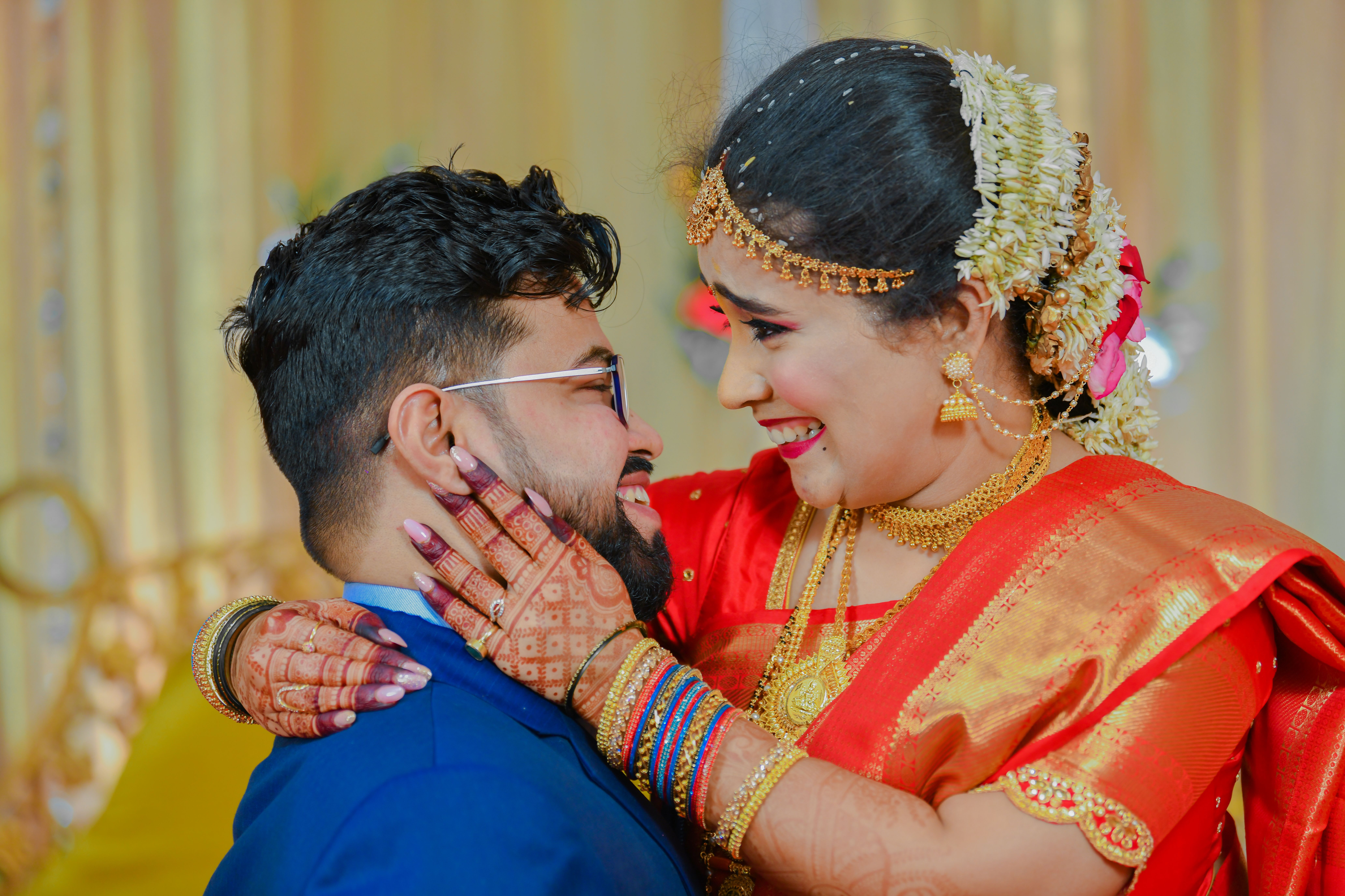 Delighted Indian couple sharing a joyful moment on their wedding day, showcasing traditional attire and love.