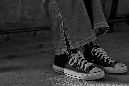 A Person Wearing Black Converse Shoes