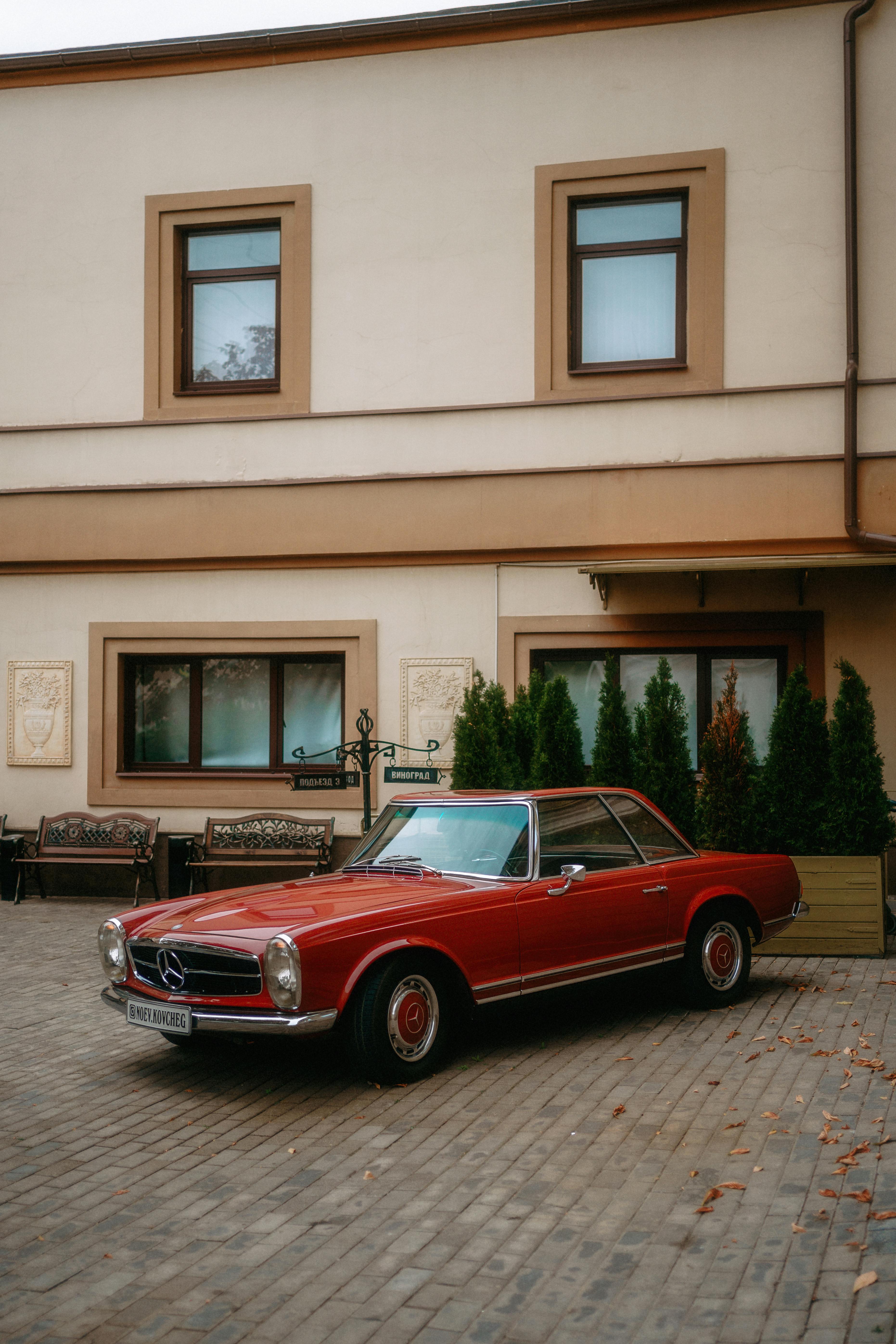 old red mercedes parked near building