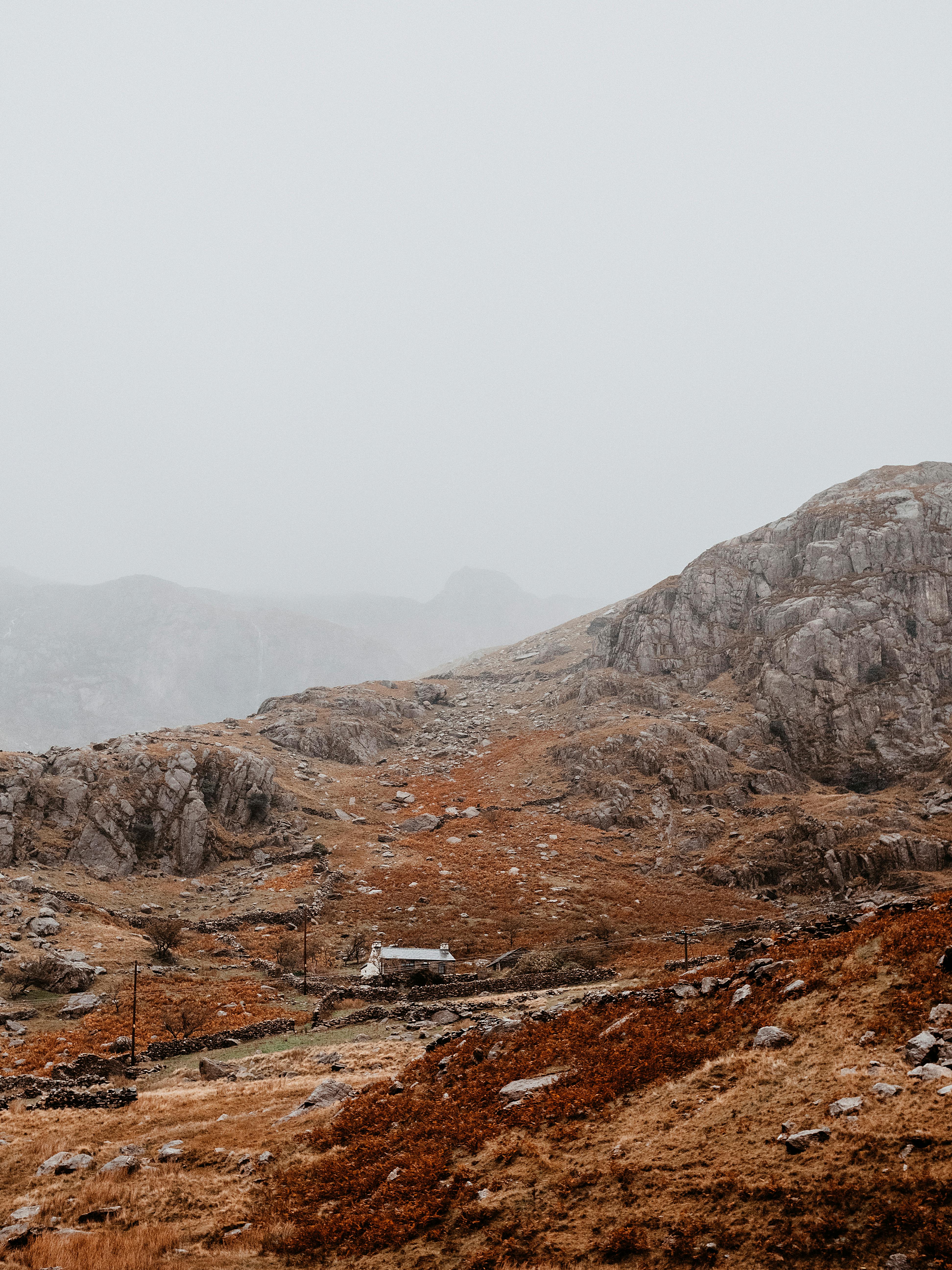 Serene misty mountains in Wales during autumn with rocky terrain.