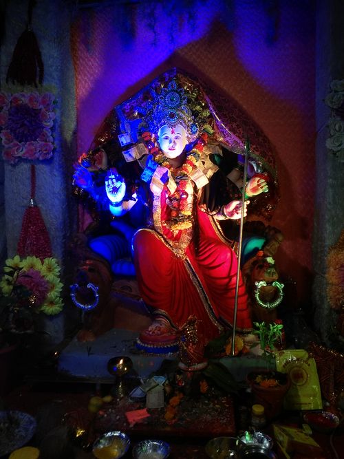 Free Colorful sculpture of a Hindu goddess adorned with flowers and lights, exuding spirituality and artistry. Stock Photo