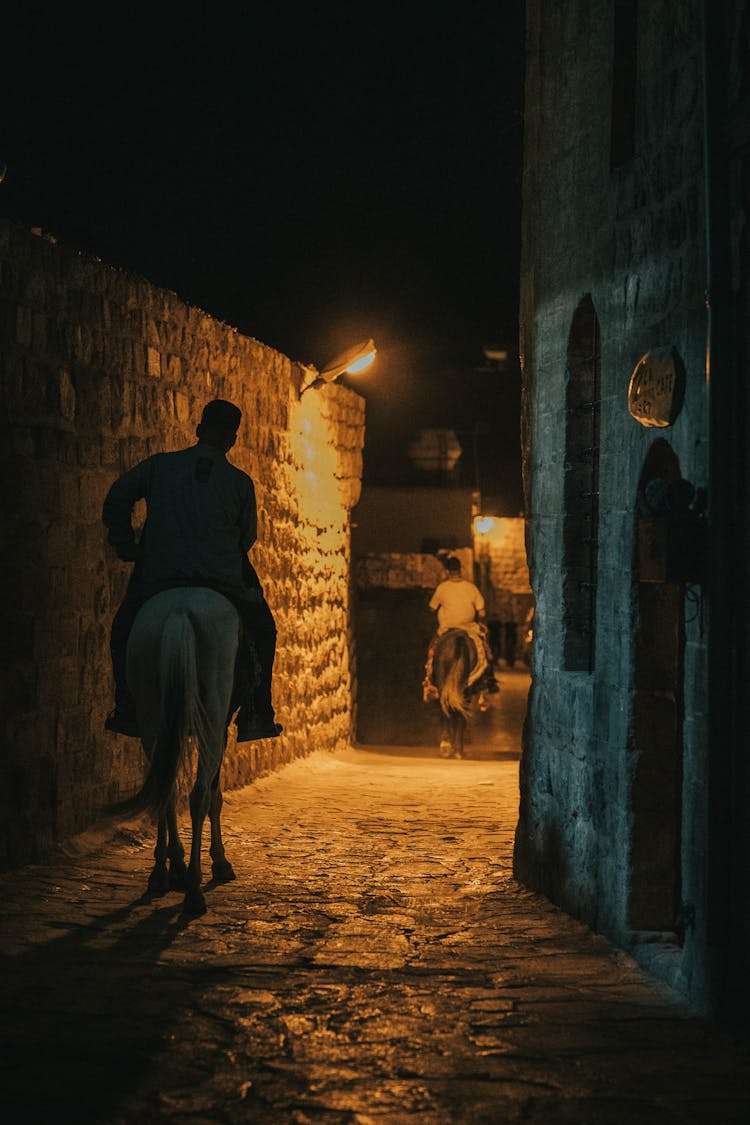 A Man Riding White Horse On The Street