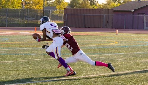 Free Two football players in action on a sunny day, showcasing a dynamic play on the field. Stock Photo