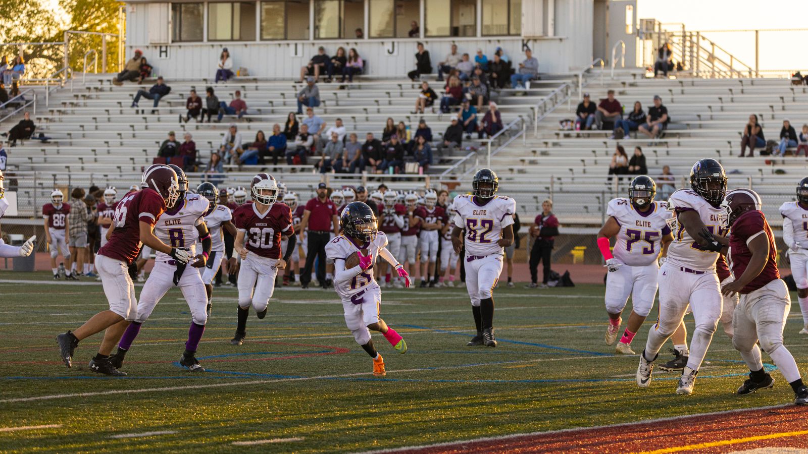 Representative licensed photograph of amateur American football players in a stadium; not Justin Tucker, Harrison Butker or a Kansas City Chiefs game