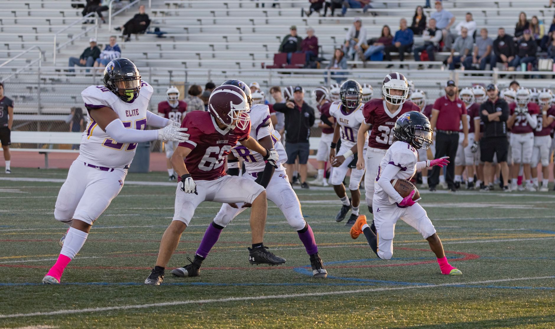 A football quarterback in shotgun formation surveying defenders under bright stadium lights before the snap
