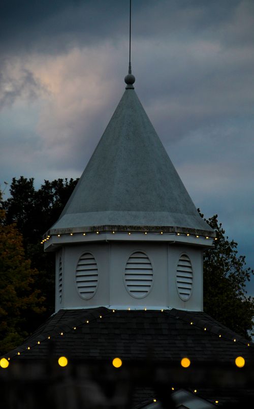 Free A quaint pavilion tower adorned with string lights set against an overcast sky, creating a serene evening ambiance. Stock Photo