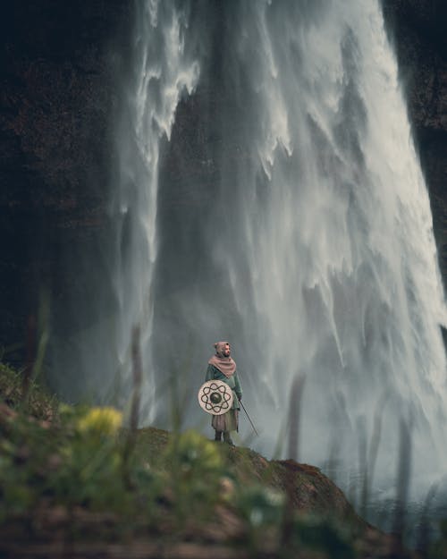 Man in Warrior Clothes under Waterfall