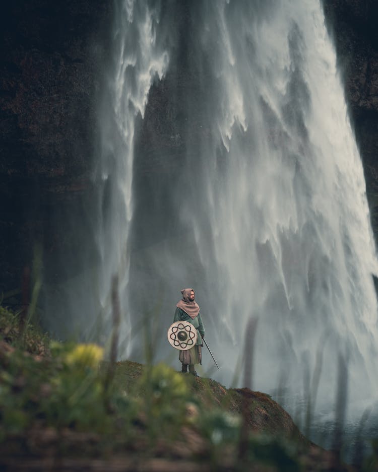 Man In Warrior Clothes Under Waterfall