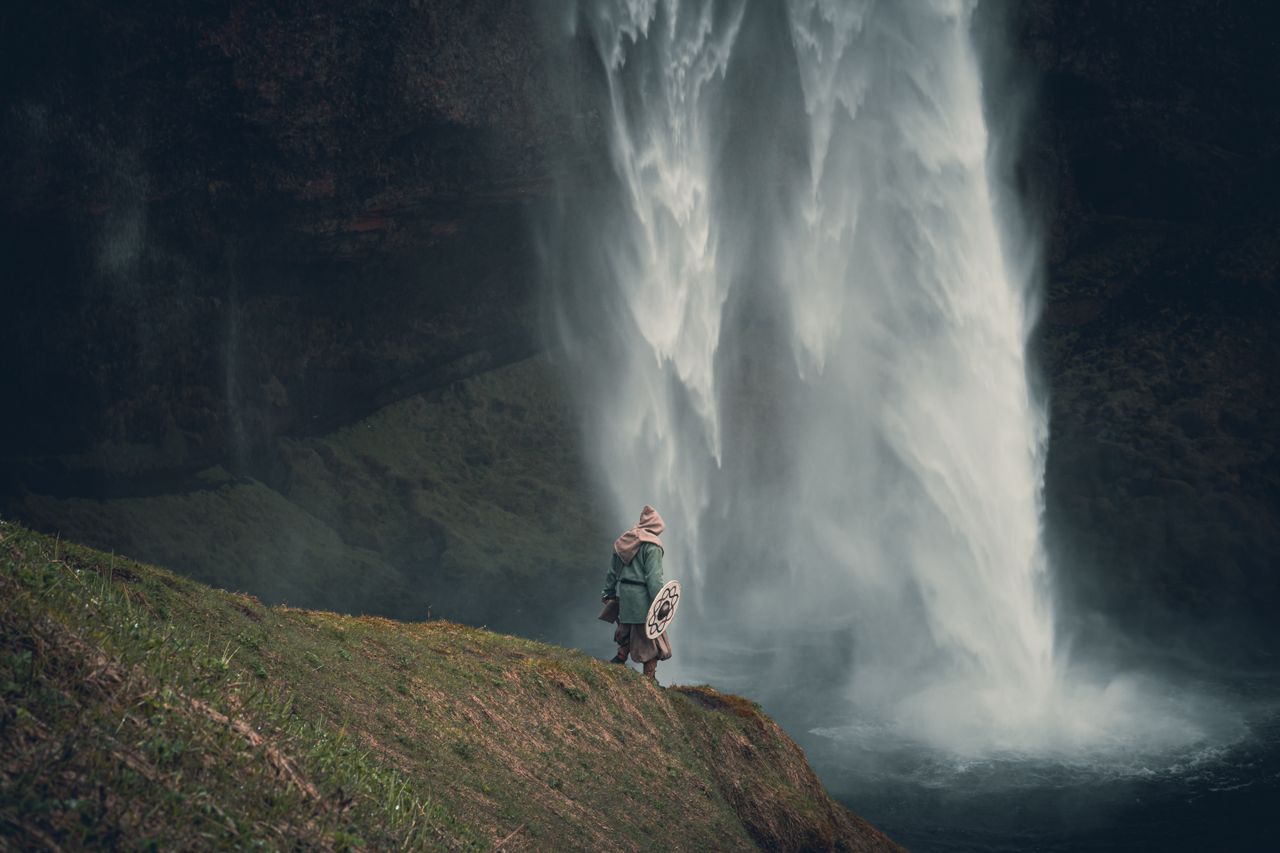 a lone warrior stands by a majestic waterfall in iceland evoking adven