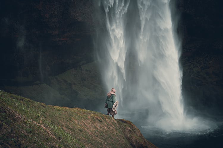 Warrior Standing By Waterfall Edge