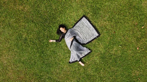 A Woman Lying on Green Grass