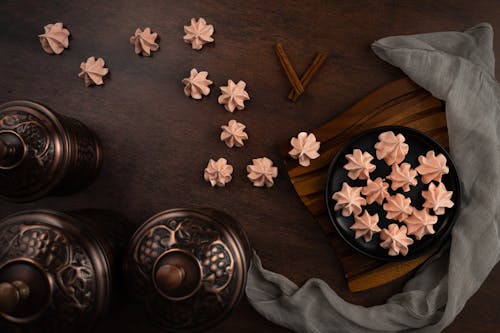 Meringue and Cinnamon Sticks on Wooden Surface