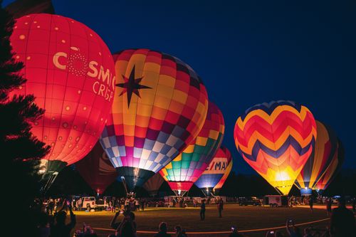 Free Colorful hot air balloons illuminated at a nighttime festival, creating a lively outdoor scene. Stock Photo