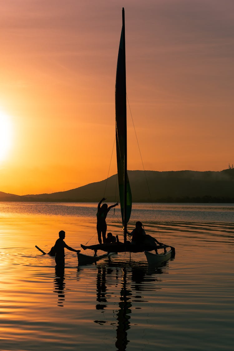 Silhouette Of People Riding On Boat During Sunset