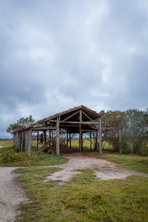 Wooden Barn Structure in a Field and Overcast in Sky