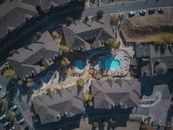 Aerial view of a residential complex with swimming pools and surrounding town architecture.