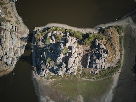 Stunning drone shot showcasing a rocky island amidst serene waters and lush greenery.