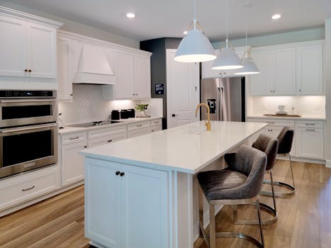 Spacious modern kitchen with a large island, white cabinetry, and elegant pendant lighting.