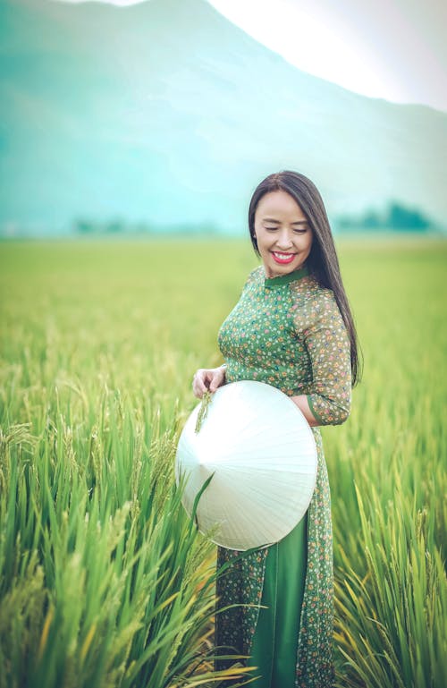 A Woman in Floral Dress Standing in the Rice Field
