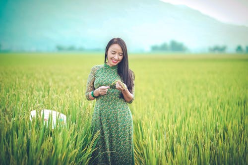 A Woman Checking the Grains in the Rice Field