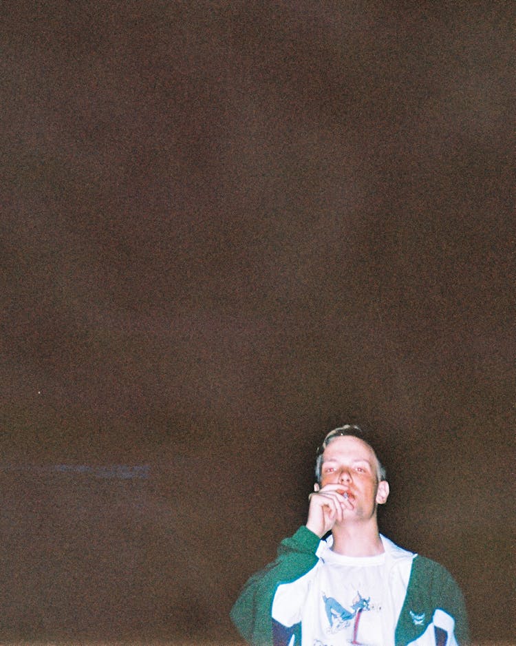 Flash Photo Of A Teenager Smoking By A Wall