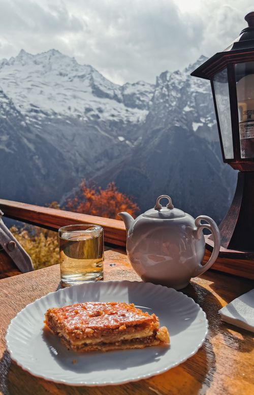 Free Enjoy breakfast on a balcony with a stunning mountain backdrop featuring snow-covered peaks. Stock Photo